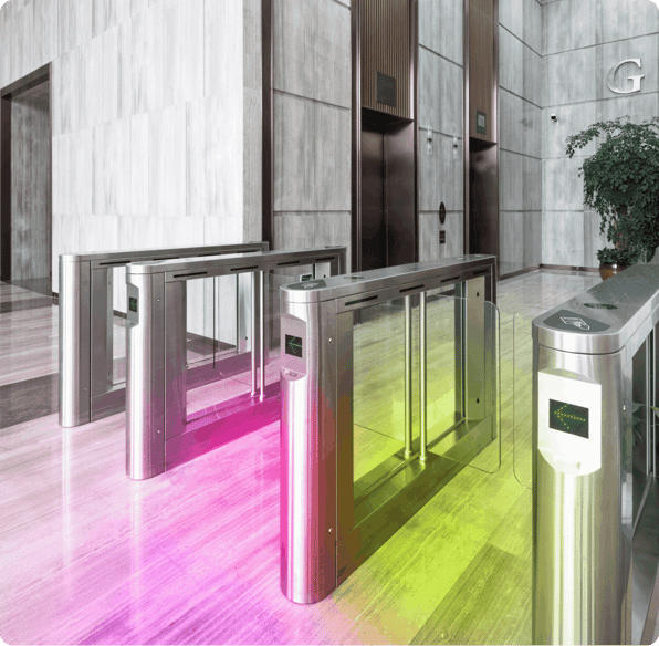 Electronic security gates in the entrance lobby of a modern office, accented with pink and lime green
